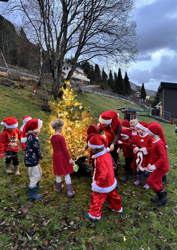 Barn ved juletre i nissedrakt - Klikk for stort bilete